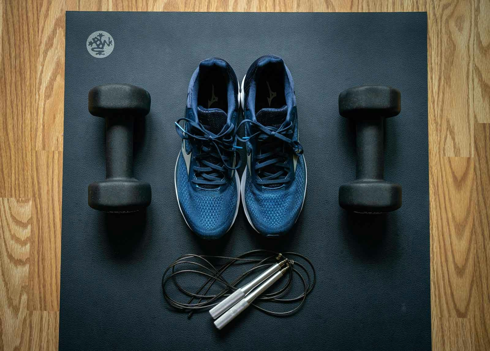 sneakers and weights on yoga mat