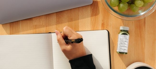 person writing in notebook